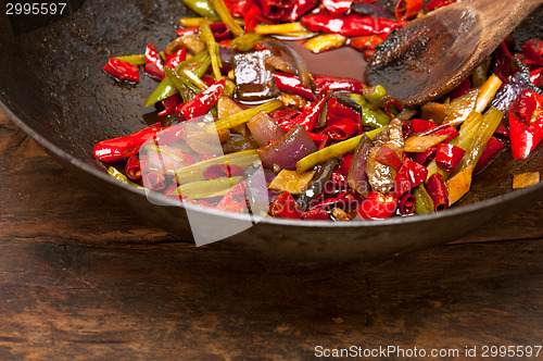 Image of fried chili pepper and vegetable on a wok pan