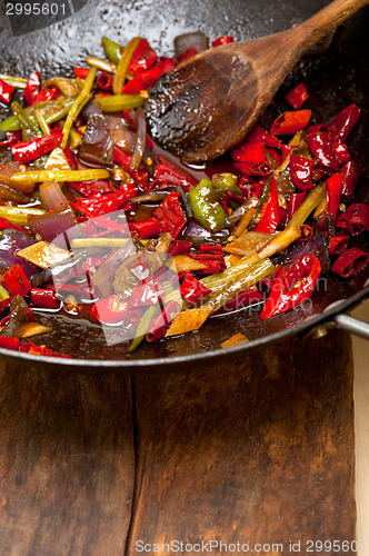 Image of fried chili pepper and vegetable on a wok pan