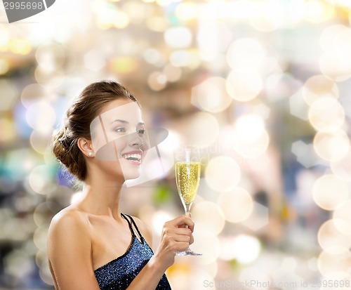 Image of smiling woman holding glass of sparkling wine