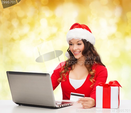 Image of smiling woman with credit card and laptop