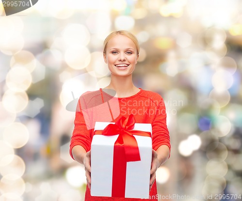 Image of smiling woman in red clothes with gift box