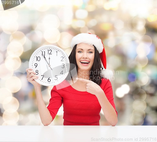 Image of smiling woman in santa helper hat with clock