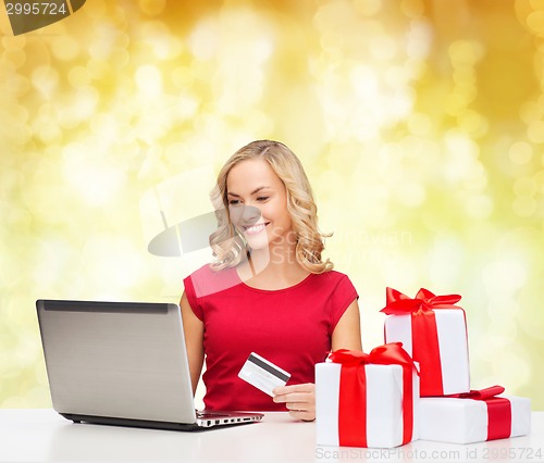 Image of smiling woman with credit card and laptop