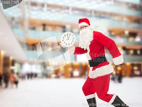 Image of man in costume of santa claus with clock