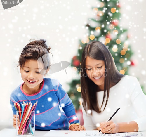 Image of mother and daughter with coloring pencils indoors