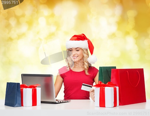 Image of smiling woman with credit card and laptop