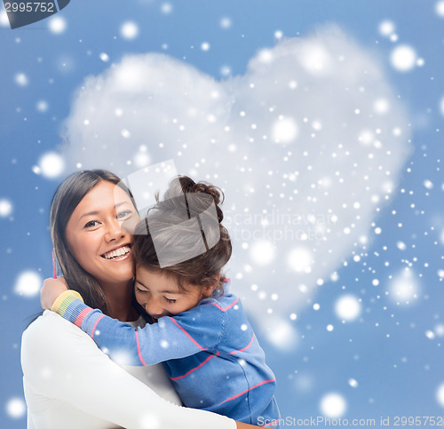 Image of smiling little girl and mother hugging indoors