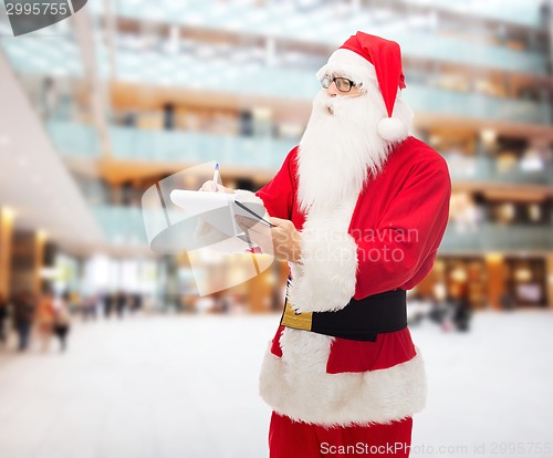 Image of man in costume of santa claus with notepad