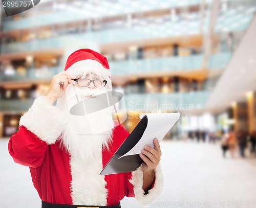 Image of man in costume of santa claus with notepad