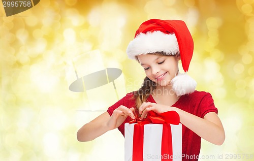 Image of smiling girl in santa helper hat with gift box