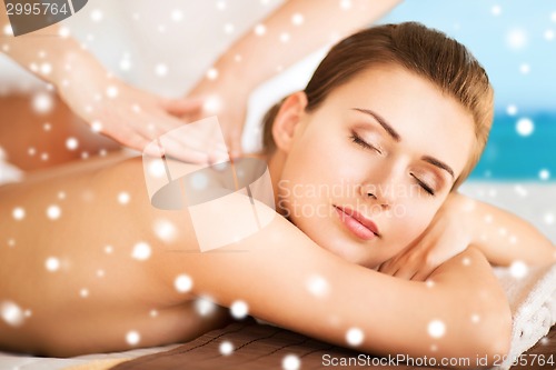 Image of beautiful young woman in spa salon getting massage