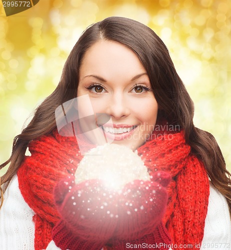 Image of smiling woman in winter clothes with snowball