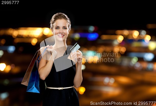 Image of smiling woman with shopping bags and credit card