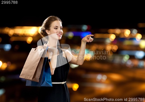 Image of smiling woman in dress with shopping bags