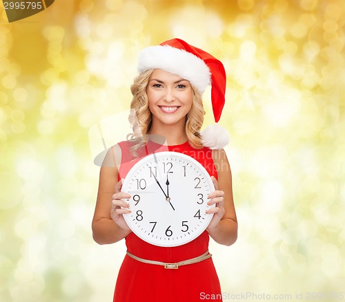 Image of smiling woman in santa helper hat with clock