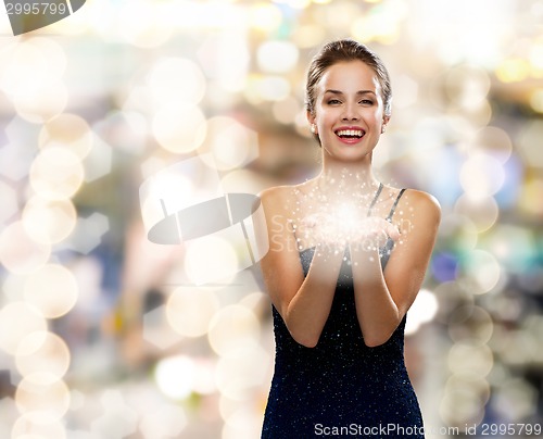 Image of laughing woman in evening dress holding something