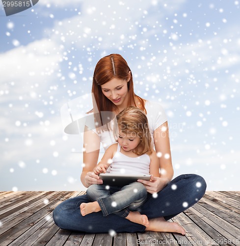 Image of happy mother with little girl and tablet pc