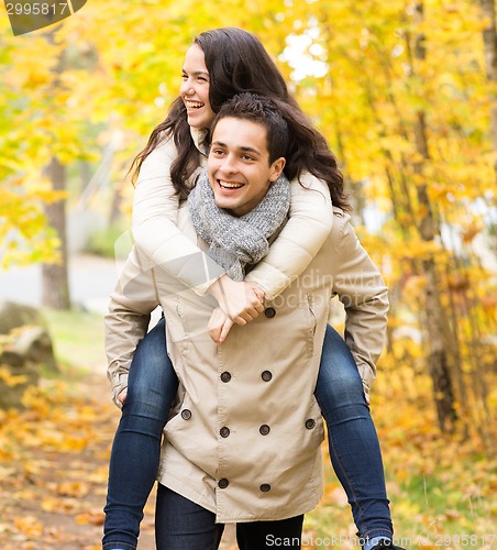 Image of smiling couple having fun in autumn park