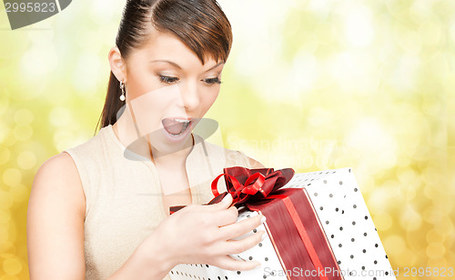 Image of smiling woman in red dress with gift box