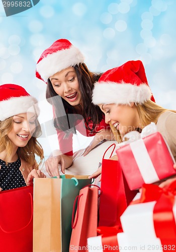 Image of smiling young women in santa hats with gifts