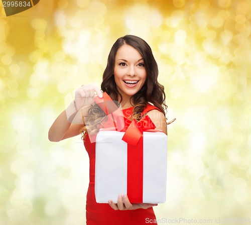 Image of smiling woman in red dress with gift boxes