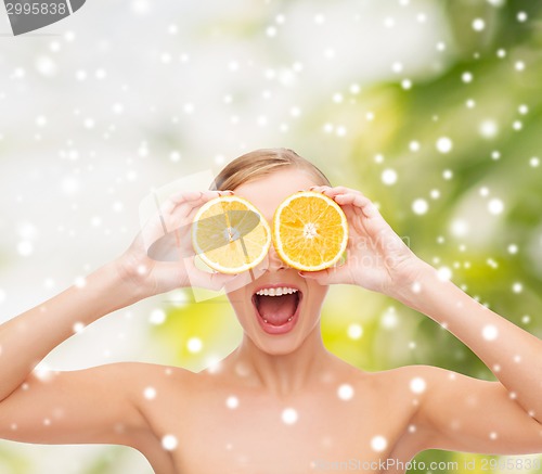 Image of amazed young woman with orange slices