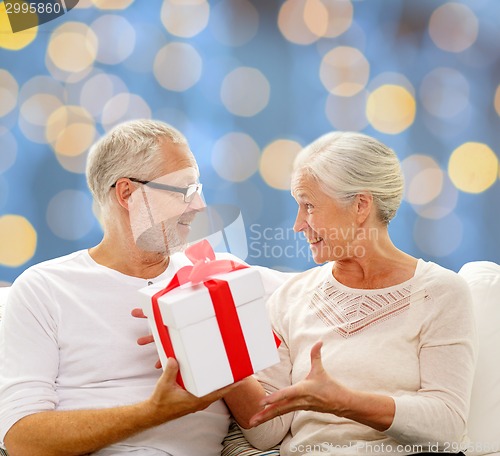 Image of happy senior couple with gift box