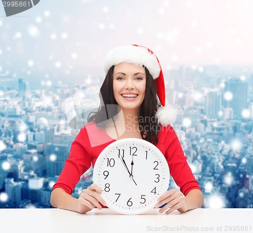 Image of smiling woman in santa helper hat with clock