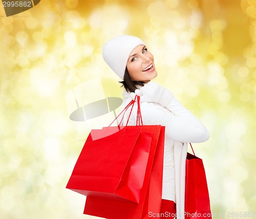 Image of smiling young woman with red shopping bags