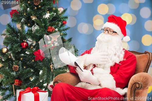 Image of man in costume of santa claus with notepad