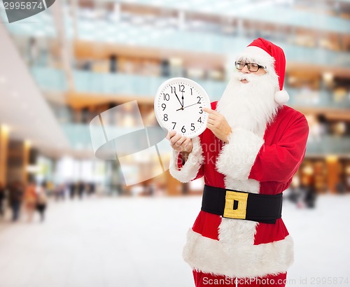 Image of man in costume of santa claus with clock