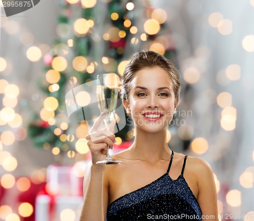 Image of smiling woman holding glass of sparkling wine