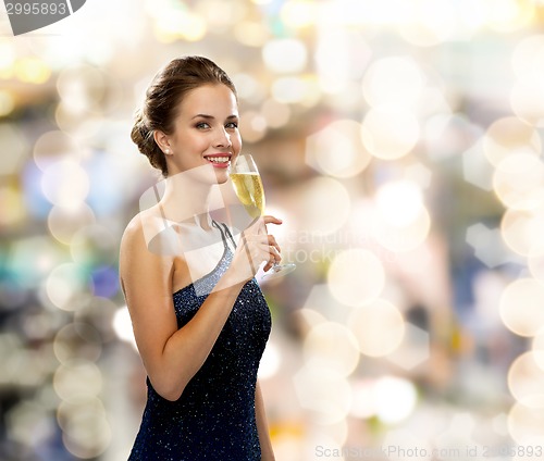 Image of smiling woman holding glass of sparkling wine