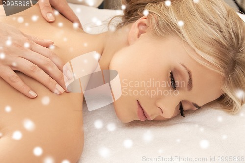 Image of beautiful young woman in spa salon getting massage