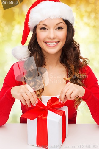 Image of smiling woman in santa helper hat with gift box