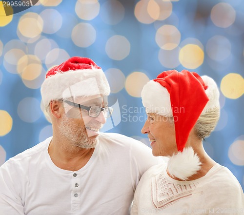 Image of happy senior couple in santa helper hats