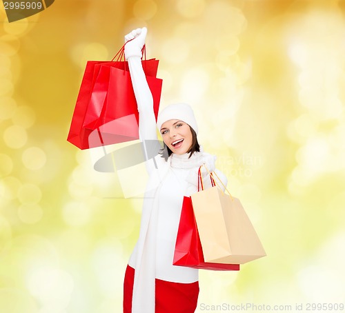 Image of smiling young woman with red shopping bags