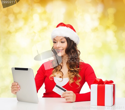 Image of smiling woman with credit card and tablet pc