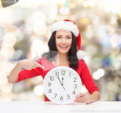 Image of smiling woman in santa helper hat with clock