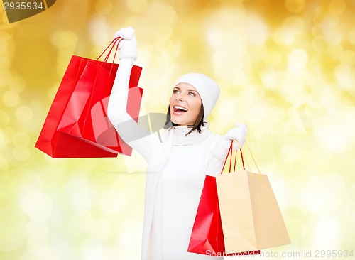 Image of smiling young woman with red shopping bags