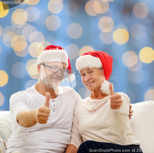 Image of happy senior couple in santa helper hats