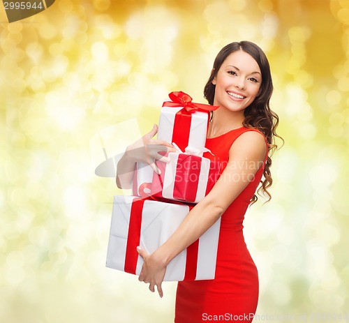 Image of smiling woman in red dress with gift boxes