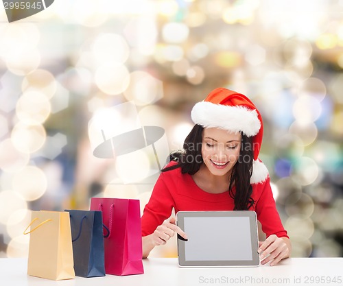 Image of smiling woman with shopping bags and tablet pc