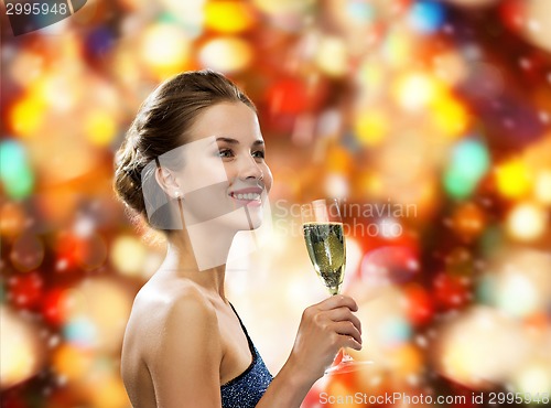 Image of smiling woman holding glass of sparkling wine