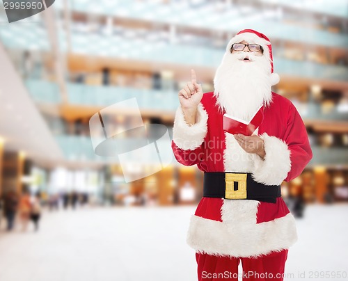 Image of man in costume of santa claus with notepad