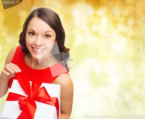 Image of smiling woman in red dress with gift box