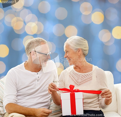 Image of happy senior couple with gift box