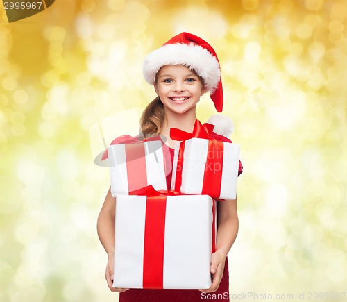 Image of smiling little girl in santa helper hat with gifts