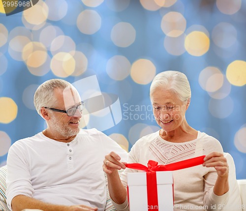 Image of happy senior couple with gift box