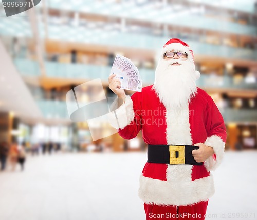 Image of man in costume of santa claus with euro money